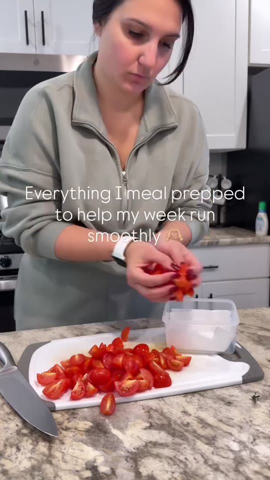 Meg slicing cherry tomatoes on a cutting board